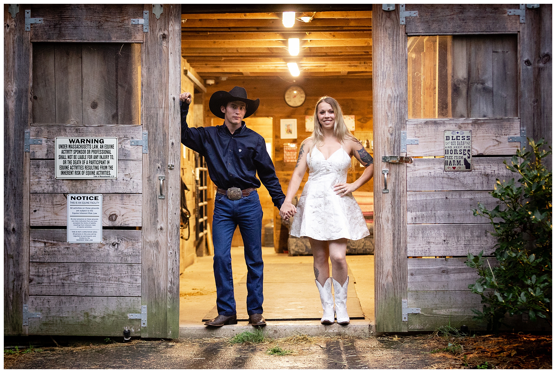 couple stands in doorway of horse barn